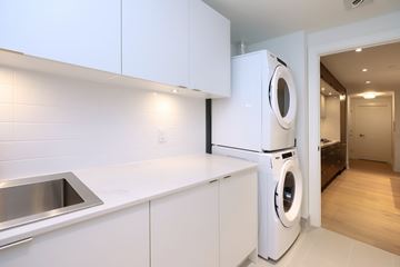 Toronto apartment for rent - A modern kitchen with white cabinets and a stainless steel sink.