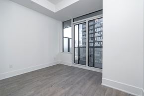 Toronto apartment for rent - A room with a large window and a wooden floor.