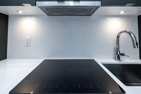 Toronto apartment for rent - A modern kitchen with a black induction cooktop.