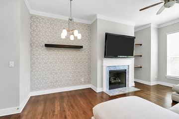 Charlotte house for rent - A living room with a fireplace and a television mounted above it.