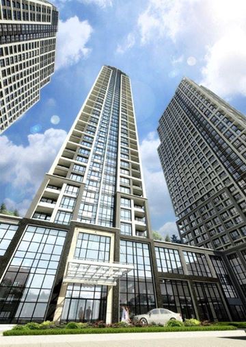 Toronto apartment for rent - A modern glass building stands tall among other buildings on a sunny day.