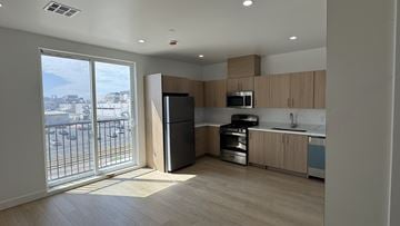 Inglewood apartment for rent - A kitchen with wooden cabinets and a black refrigerator.
