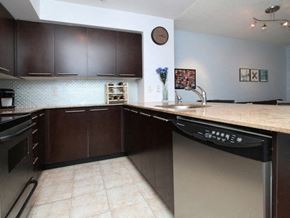 Toronto apartment for rent - A kitchen with dark brown cabinets and a stainless steel dishwasher.