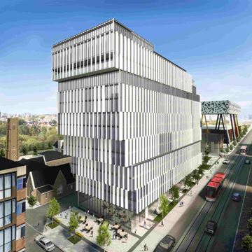 Toronto apartment for rent - A modern building with a lot of windows is being constructed next to a road.