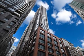 Toronto apartment for rent - A tall building with a glass facade stands in front of other buildings.