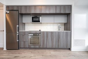 Toronto apartment for rent - A modern kitchen with a stainless steel refrigerator and a microwave above the oven.