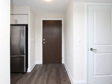 Etobicoke apartment for rent - A kitchen with a refrigerator and a door.