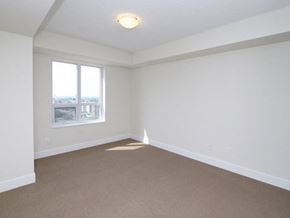 Etobicoke apartment for rent - Empty room with carpeted floor and a window.