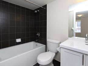 Etobicoke apartment for rent - A white toilet sits next to a bathtub in a bathroom.
