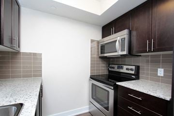 Etobicoke apartment for rent - A kitchen with a stove top oven and microwave above it.