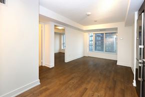 Toronto apartment for rent - A spacious room with wooden floors and white walls.