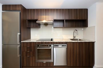 Toronto apartment for rent - A modern kitchen with a stainless steel refrigerator and wooden cabinets.