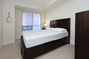 Toronto apartment for rent - A bedroom with a large bed and a window with blinds.