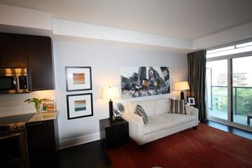 Toronto apartment for rent - A living room with a white couch and a large picture on the wall.
