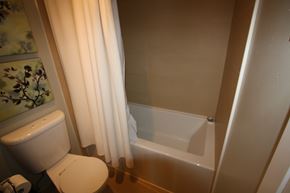 Toronto apartment for rent - A white toilet sits next to a bathtub in a bathroom.