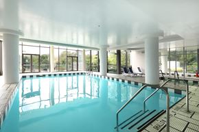 Toronto apartment for rent - A large indoor swimming pool with a metal ladder.