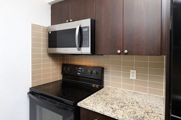 Toronto apartment for rent - A kitchen with a black oven and a microwave above it.