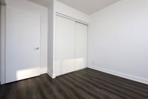 Toronto apartment for rent - A room with a white door and a brown floor.