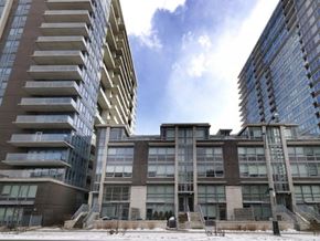Toronto apartment for rent - A large building with a lot of windows is in the foreground with a smaller building behind it.