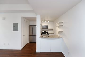 Toronto apartment for rent - A kitchen with white cabinets and a stainless steel refrigerator.