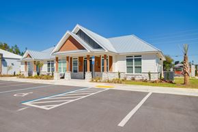 Pensacola apartment for rent - A building with a parking lot in front of it.