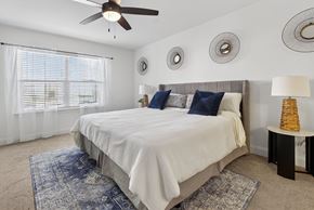 Pensacola apartment for rent - A bedroom with a large bed and a ceiling fan.