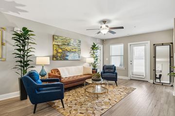 Ocala apartment for rent - A living room with a blue chair and a brown couch.