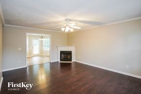Murfreesboro house for rent - A spacious living room with a fireplace and a ceiling fan.