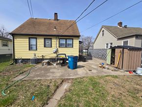 Gary house for rent - A yellow house with a blue barrel in front of it.