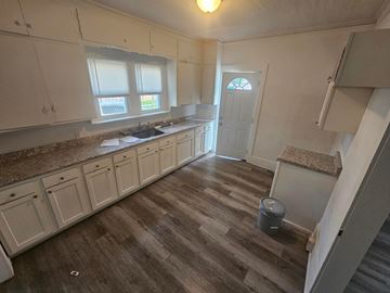 Lima house for rent - A kitchen with white cabinets and a brown counter top.
