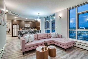 Calgary house for rent - A living room with a pink couch and a marble backsplash.