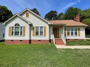 Wilson house for rent - A house with a red brick base and yellow shutters.