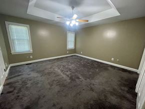 Wilson house for rent - A room with a ceiling fan and carpeted floor.