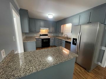 Wilson house for rent - A kitchen with granite countertops and stainless steel appliances.