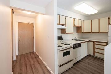 Prince Albert apartment for rent - A kitchen with a stove top oven and a doorway leading to a hallway.