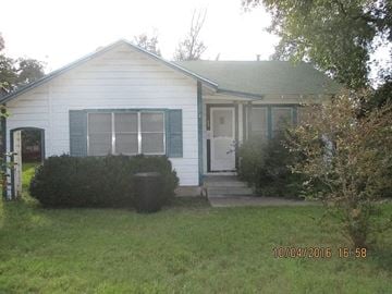 San Angelo house for rent - A small white house with a green roof and a small porch.