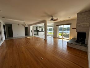 Annapolis house for rent - A spacious room with wooden floors and a fireplace.