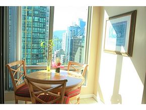 Vancouver apartment for rent - A dining room with a table and chairs and a view of the city.