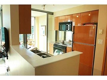 Vancouver apartment for rent - A kitchen with a white counter top and brown cabinets.