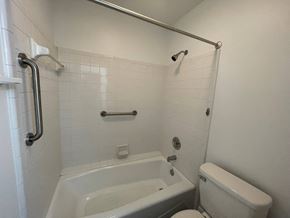 Wilson house for rent - A white bathroom with a tub, toilet and sink.