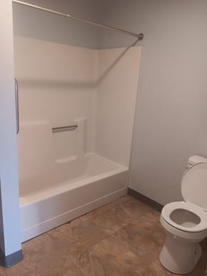 Shinnston apartment for rent - A white toilet is in a bathroom with a walk-in shower.