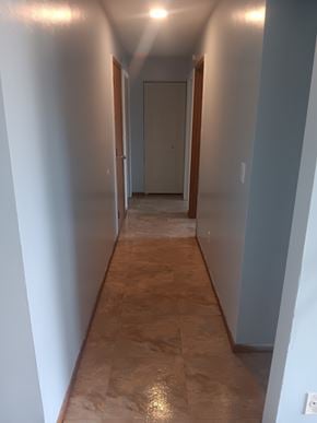Shinnston apartment for rent - A long hallway with a tan floor and white walls.