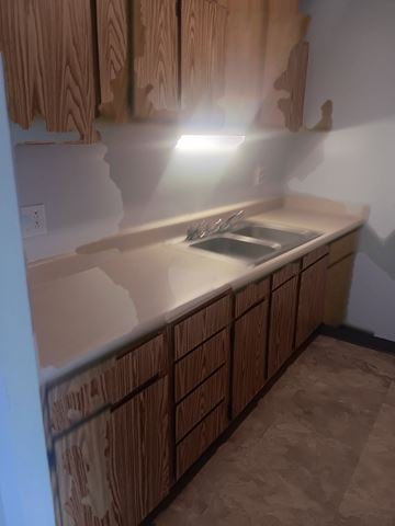 Shinnston apartment for rent - A kitchen with wooden cabinets and a countertop.