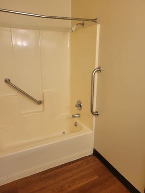 Grafton apartment for rent - A white bathtub with a silver faucet and grab bar.