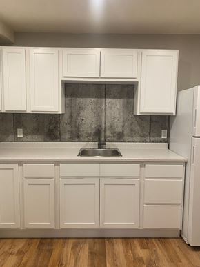 Dartmouth apartment for rent - A kitchen with white cabinets and a wooden floor.