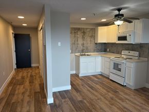 Dartmouth apartment for rent - A kitchen with white cabinets and a wood floor.