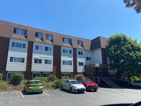 Dartmouth apartment for rent - A parking lot with cars and a building in the background.