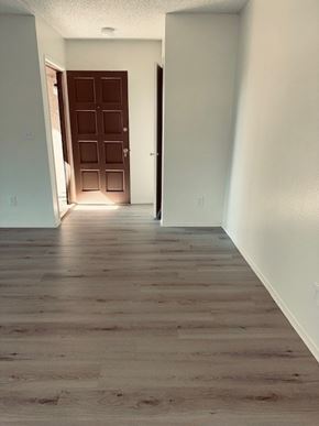 Fullerton apartment for rent - A room with a wooden floor and a brown door.
