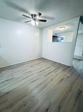 Tustin apartment for rent - A room with a ceiling fan and wooden flooring.