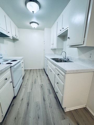 Tustin apartment for rent - A kitchen with white appliances and cabinets.